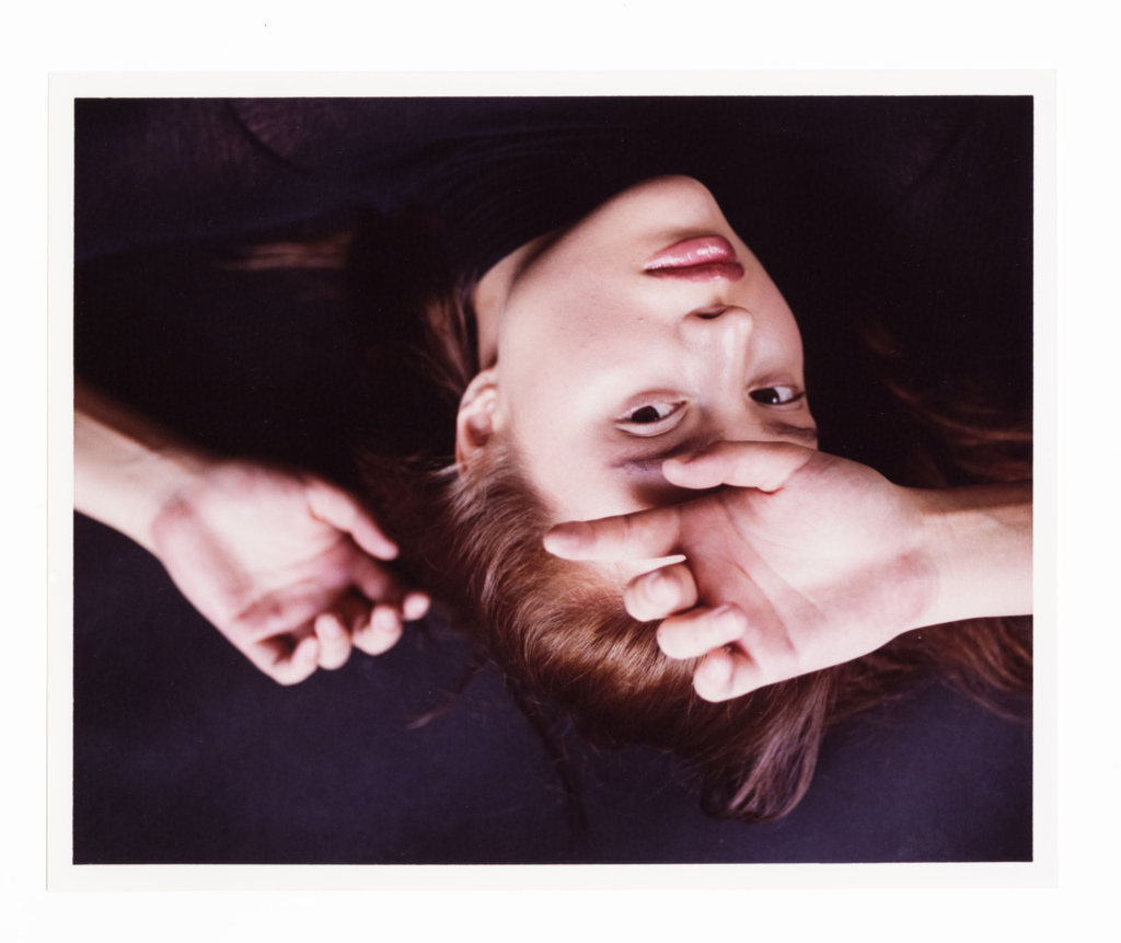 Young woman lying down with hand over her face