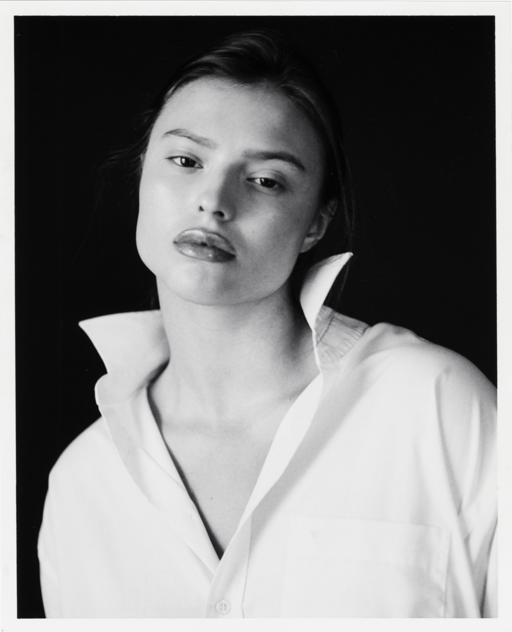 Black and white portrait of young woman wearing a white shirt