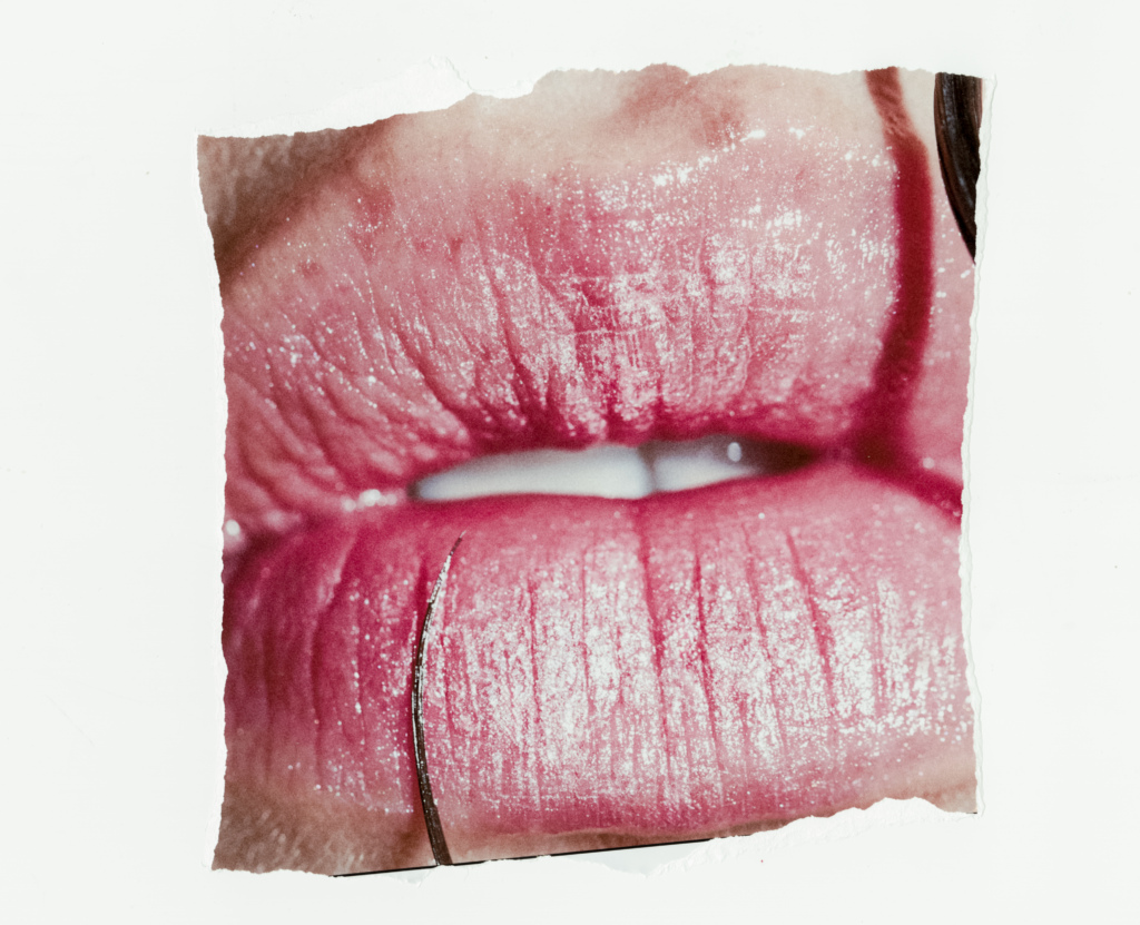 Detail of a young woman's lips wearing frosted pink lipstick