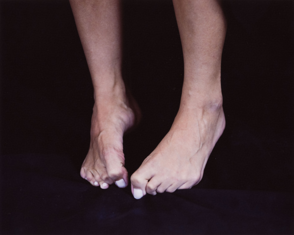 Detail of a woman's toes clutching black fabric
